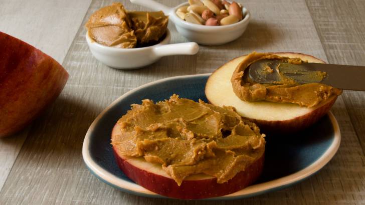peanuts, and peanut butter spread on an apple