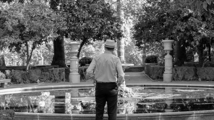 older man looking into a fountain