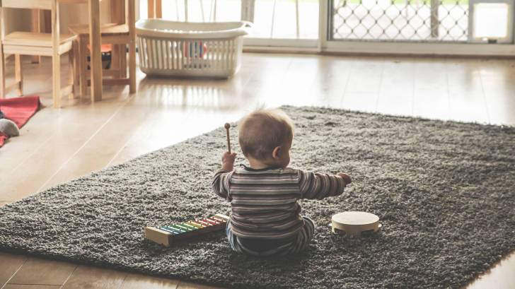 toddler on the floor playing with musical instruments