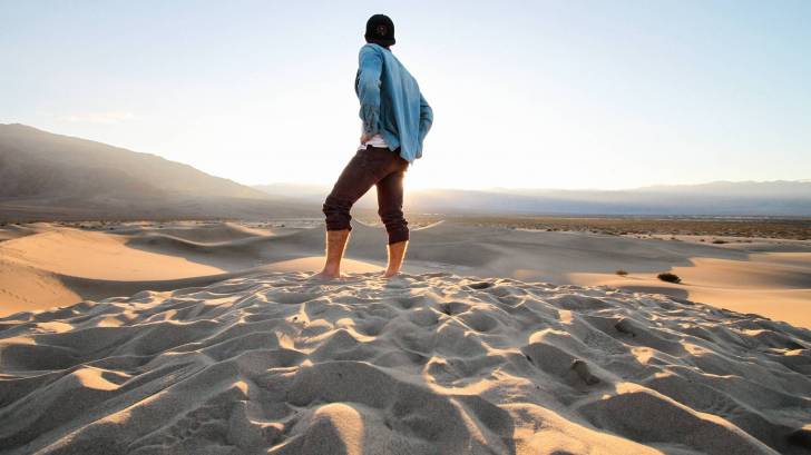 man standing in the desert by himself contemplating life