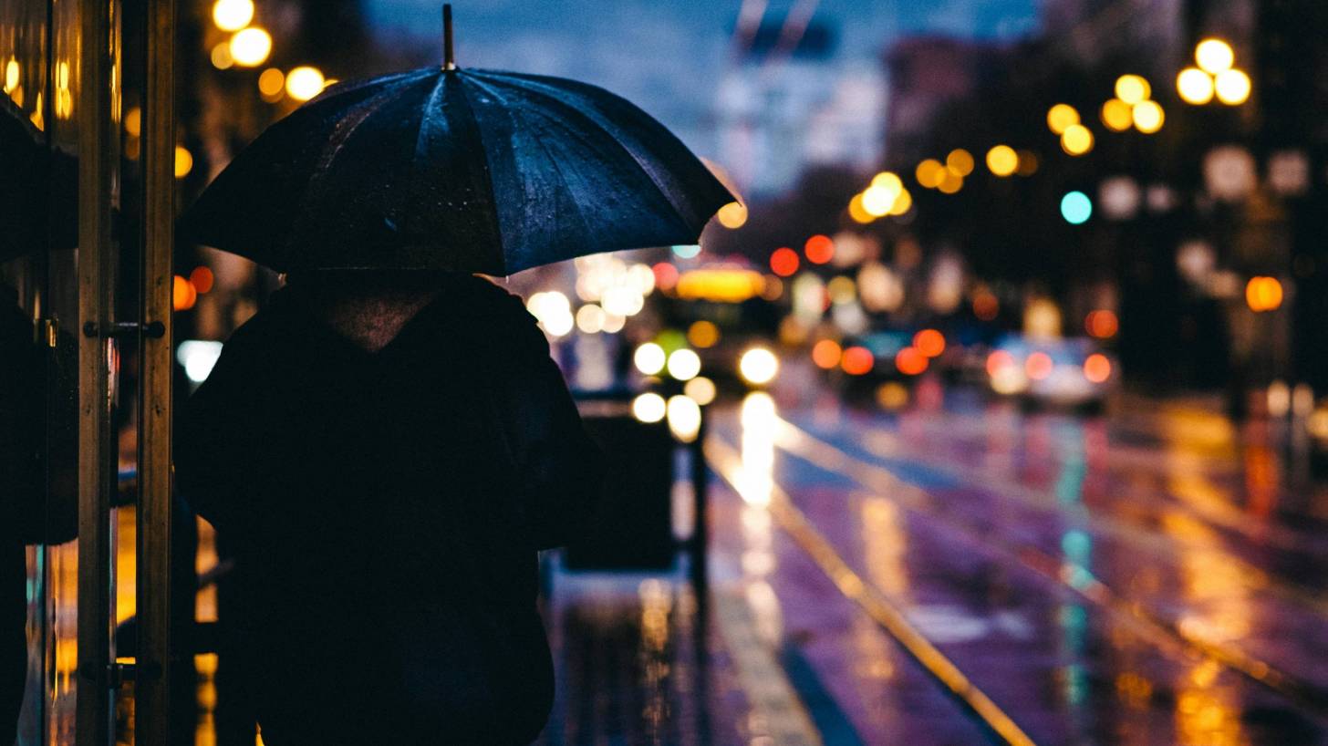 adult with umbrella in a city alone