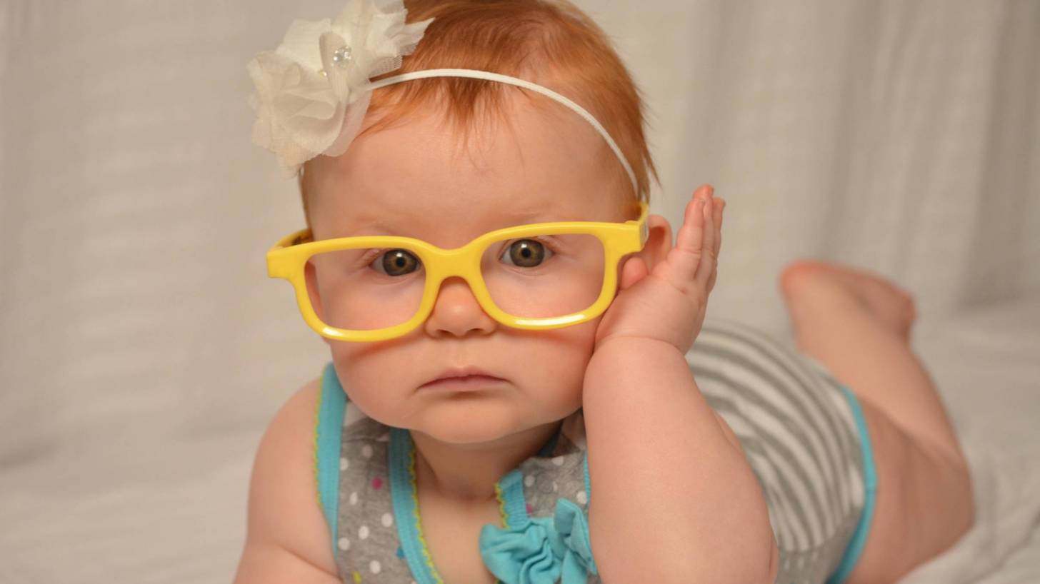 happy healthy little girl with yellow glass frames on