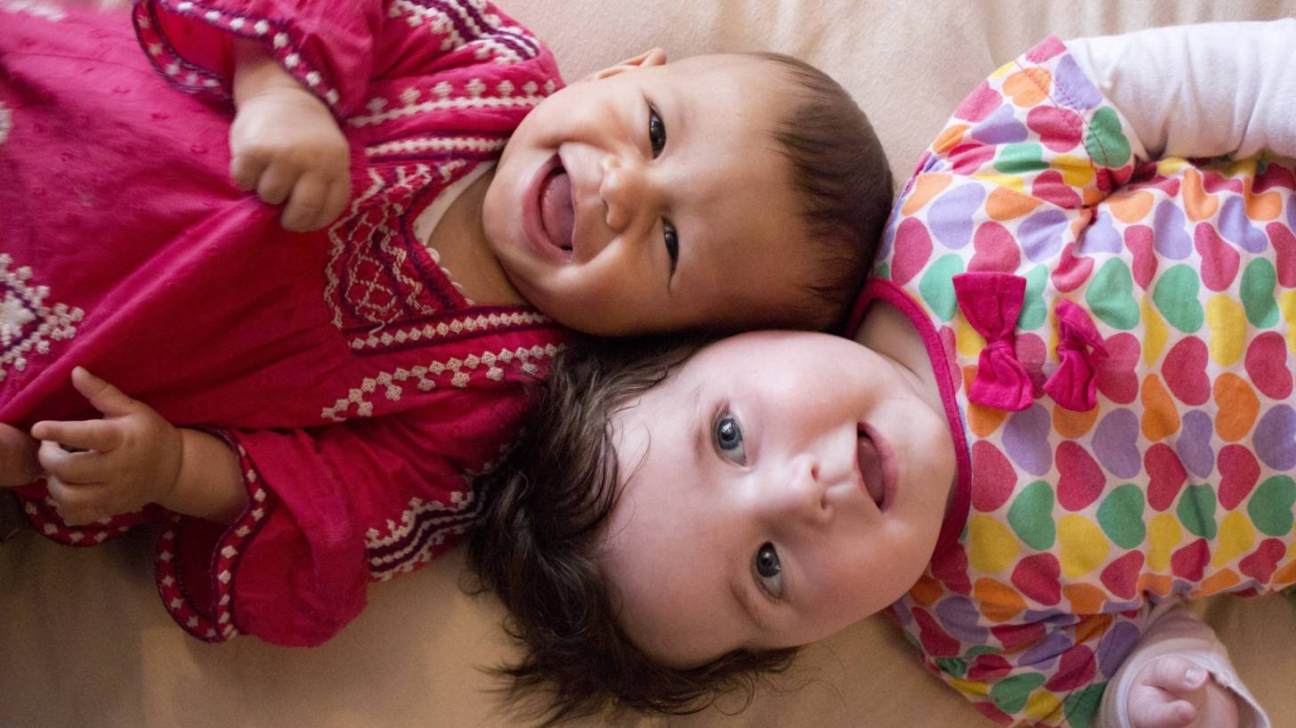 young babies healthy and smiling laying head to head