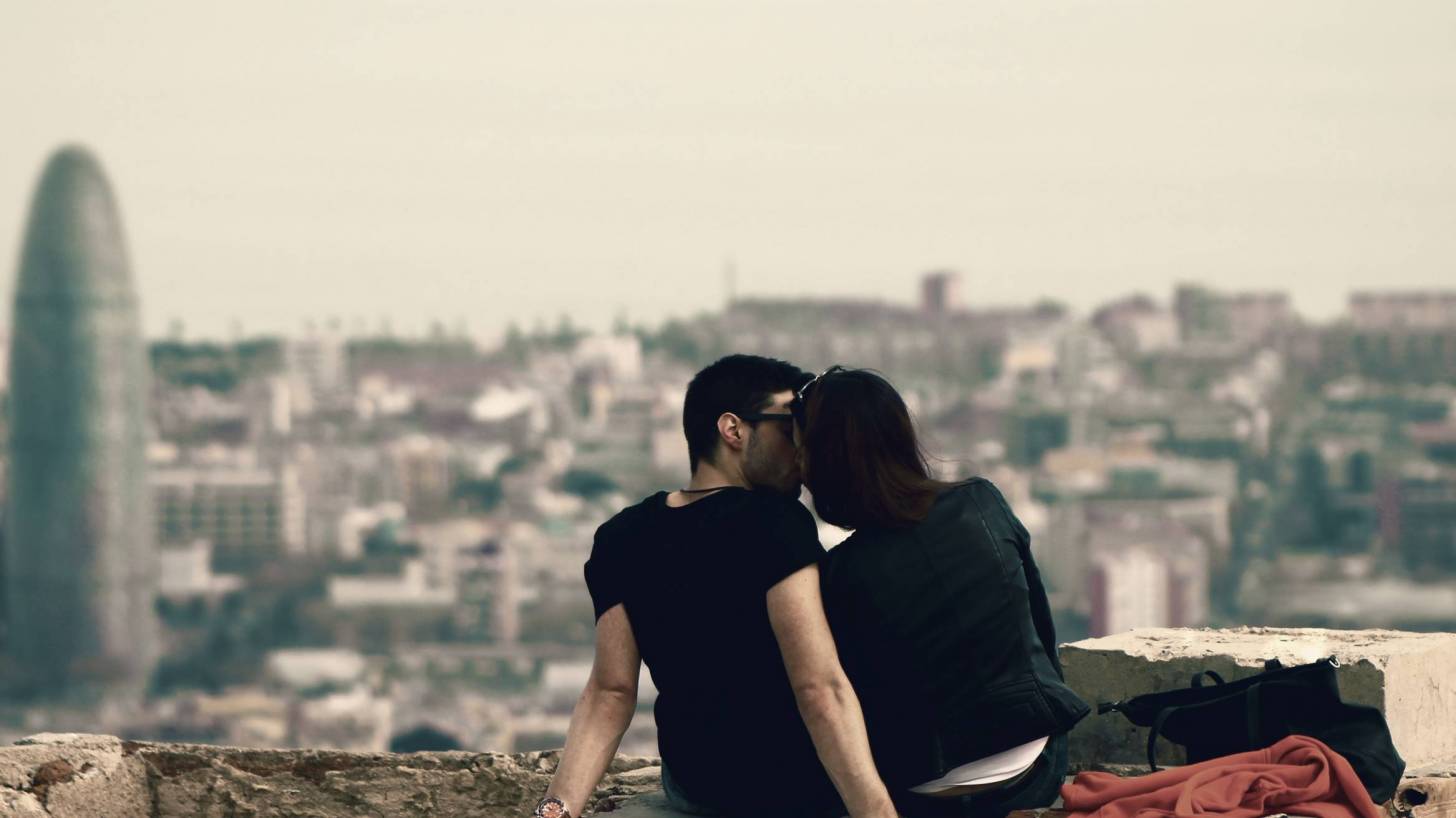 couple sharing a kiss overlooking barcelona