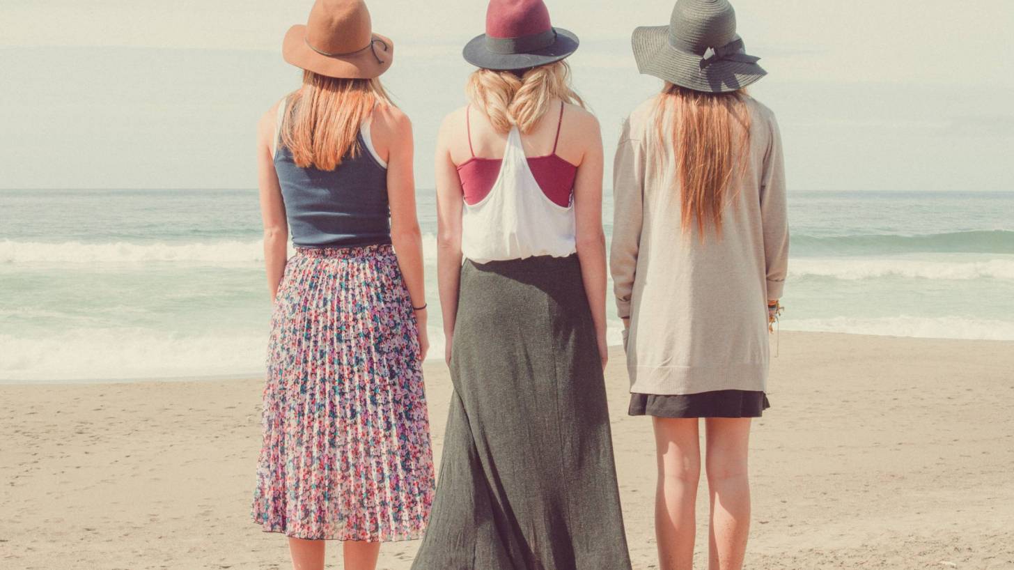 three young women string at the ocean