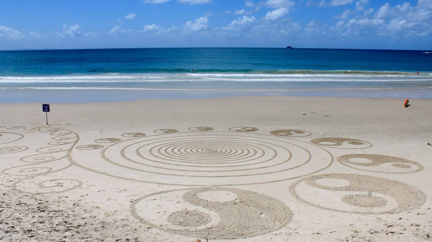 yin and ynag artwork on a beach