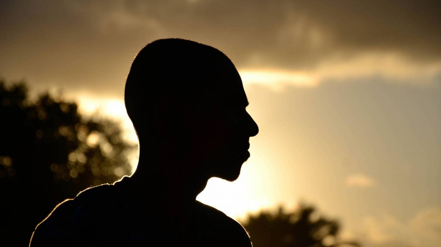 profile of man looking at a sunset