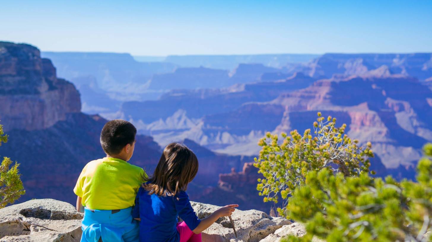 children sitting at the top of a canyon