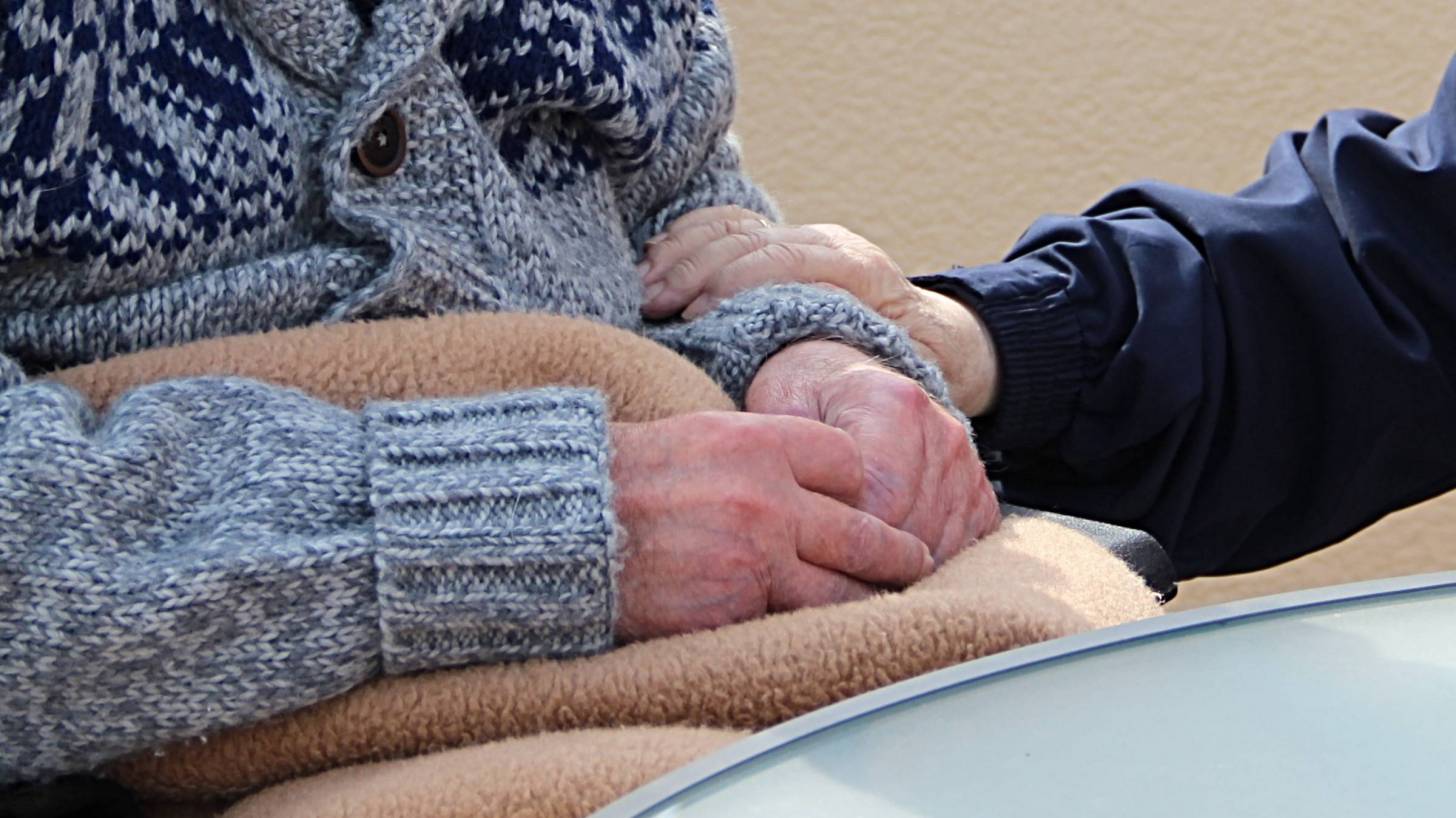 older person in nursing home being taken care