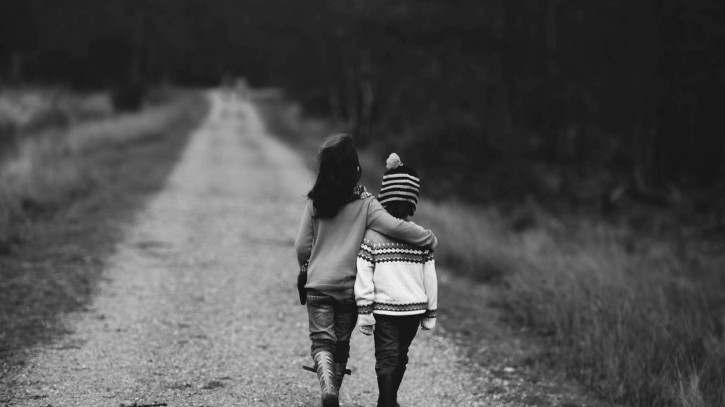 two young children walking down the road together
