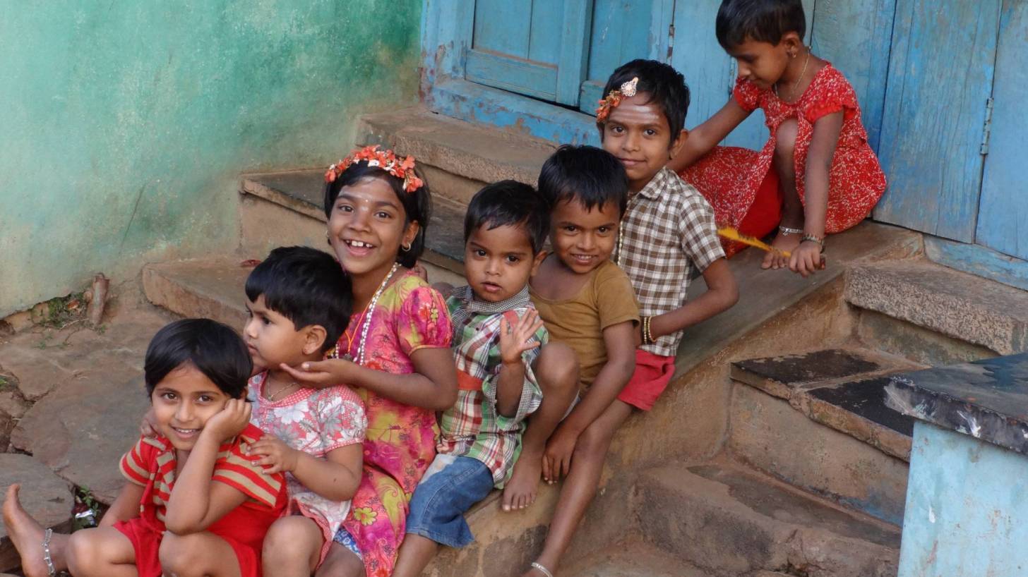 Indian children sitting on steps, happy