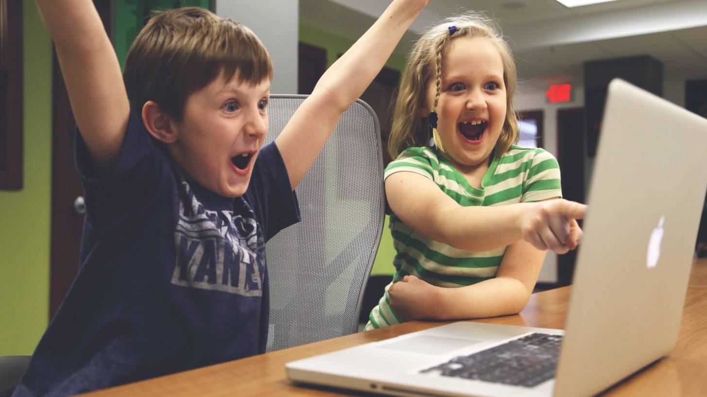 children happy looking at a computer screen