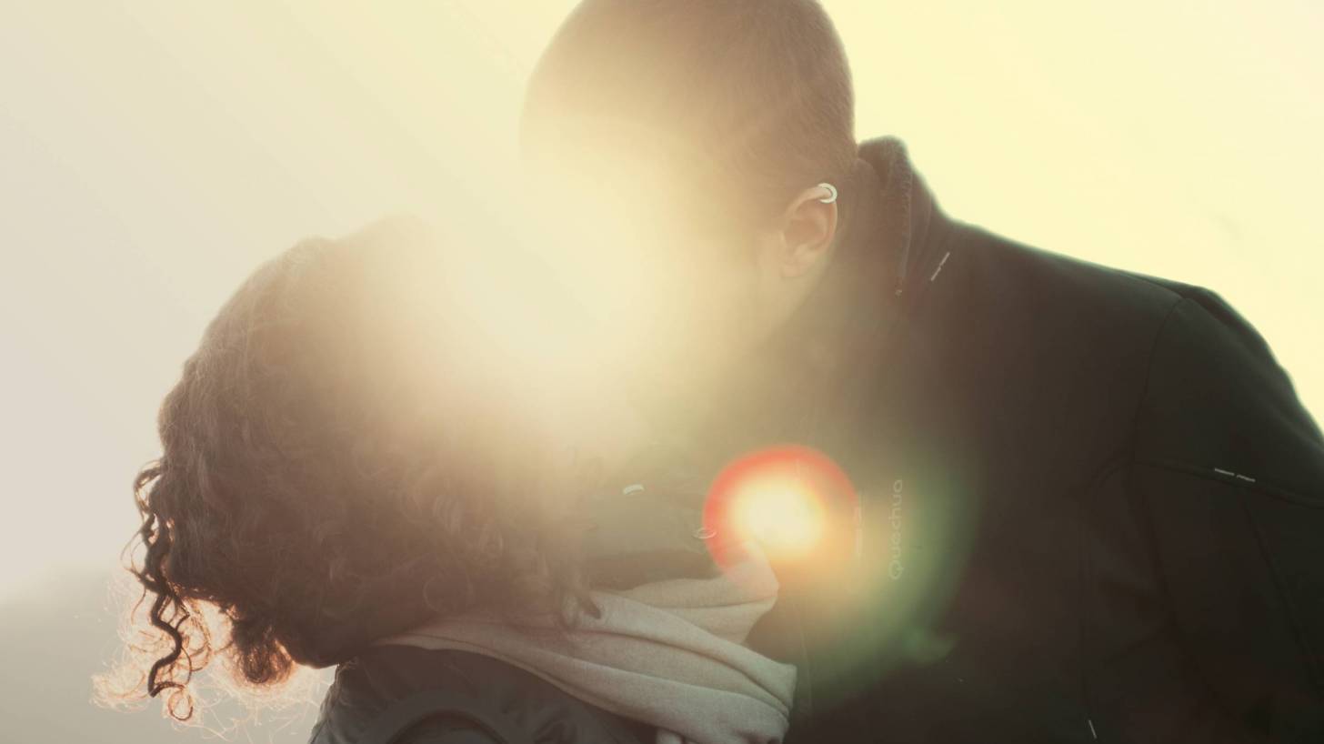 happy couple kissing in the sunlight