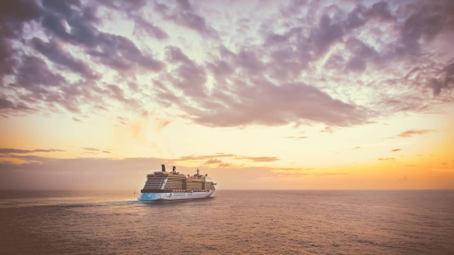 cruise ship on the ocean sun setting behind