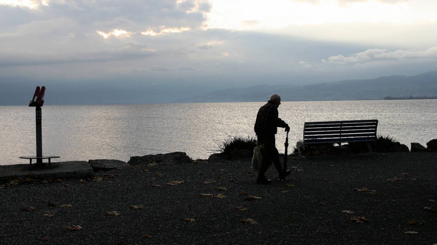 older man walking arounf the lake