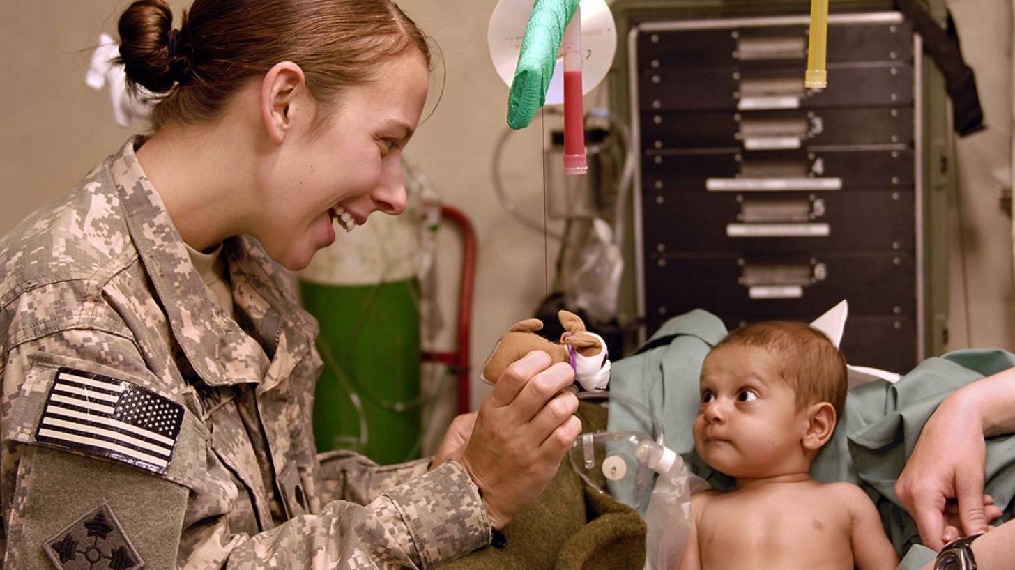 army doctor taking care of an infant patient