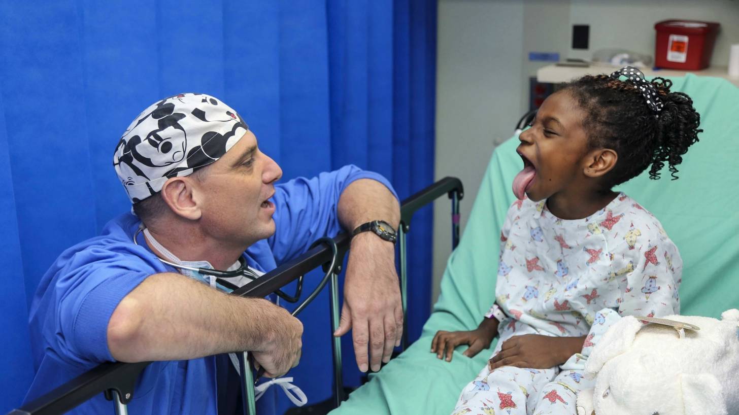 hospital doctor talking to a child in a bed
