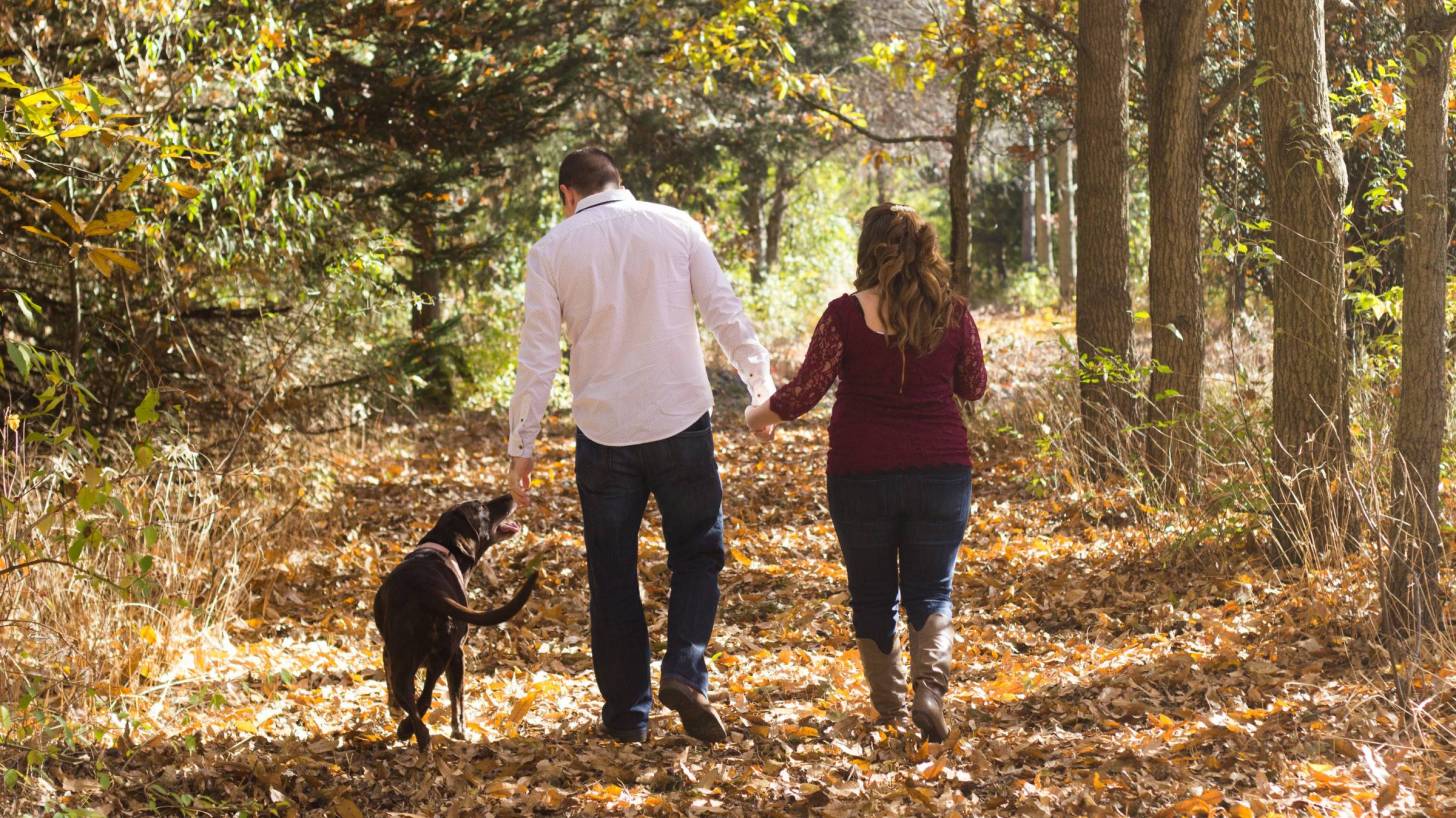 couple with dog hiking in the woods