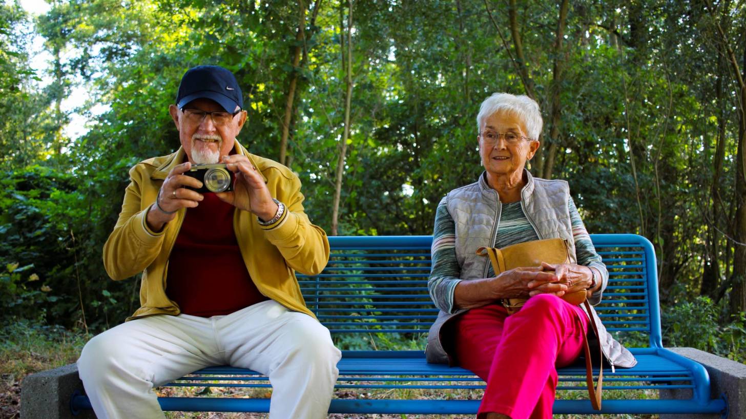 grandparents sitting on a bench taking photos