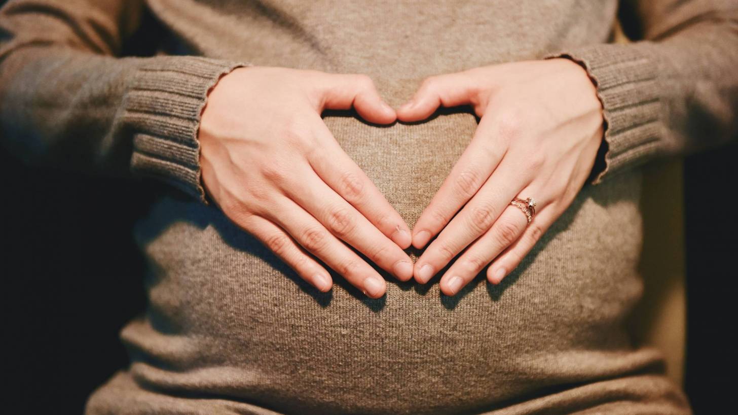 Pregnant mom with heart shaed hands
