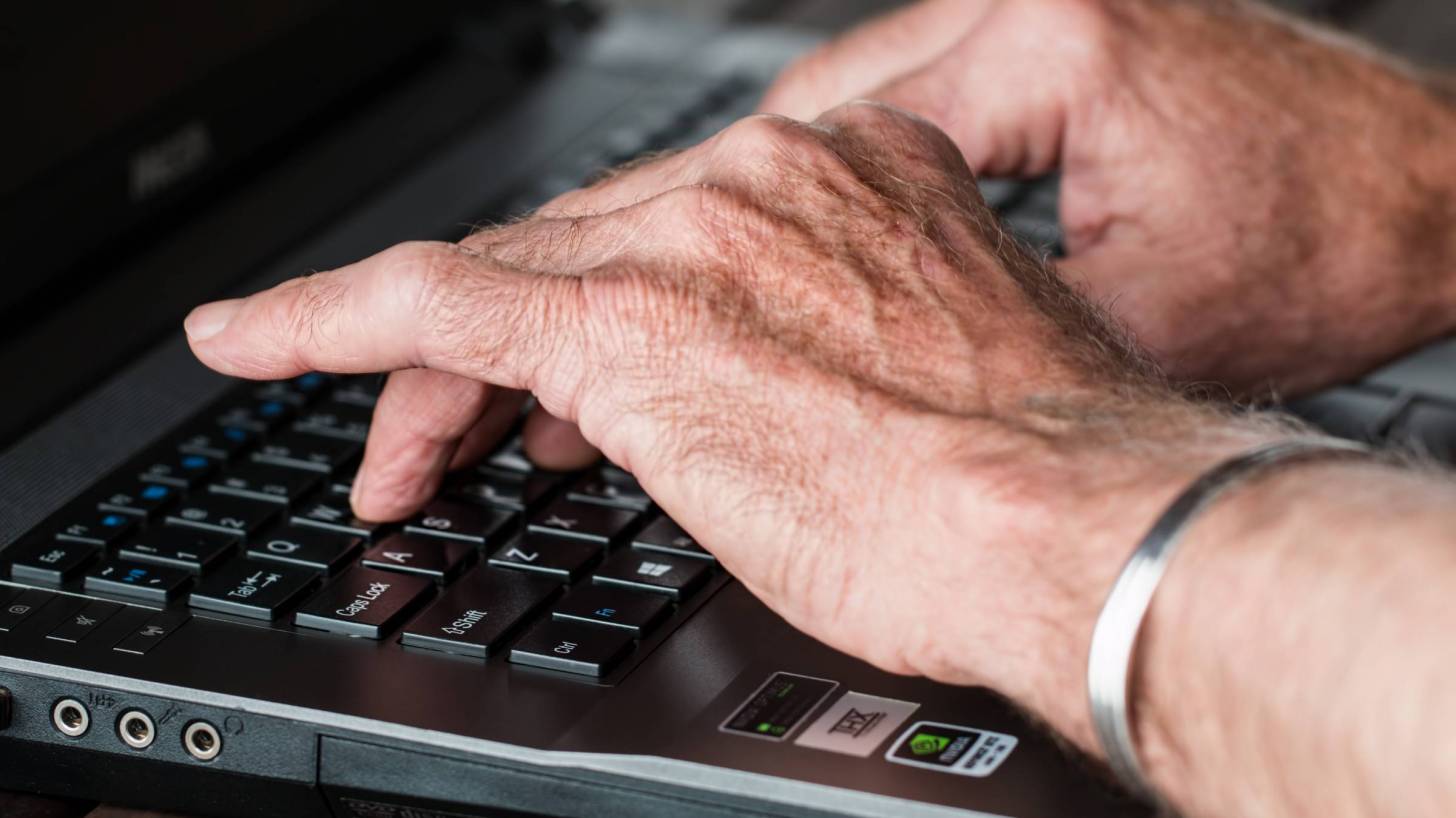 old hands typing on key board