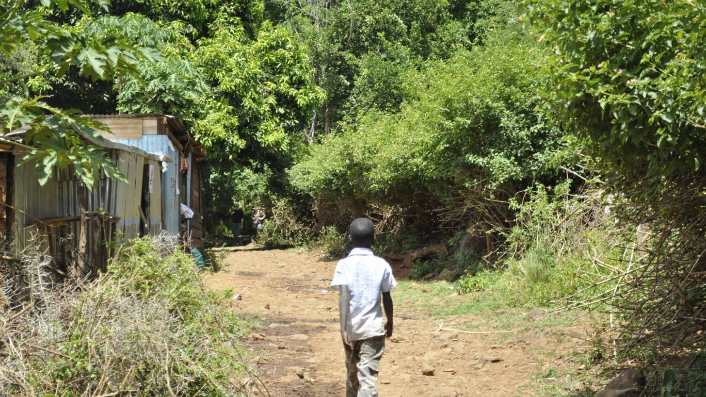 young boy walkng through a village