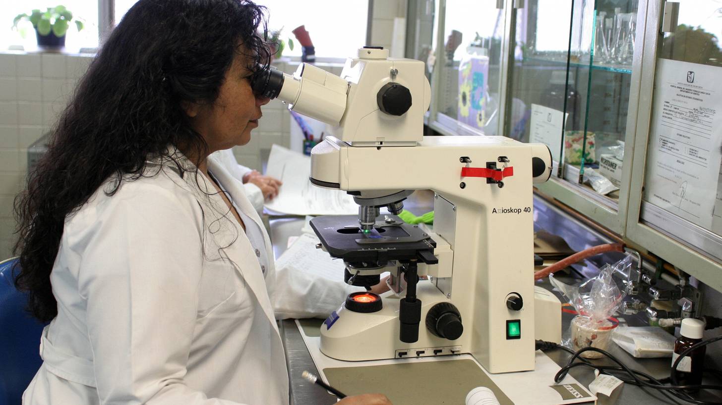 women doctor looking thru a microscope