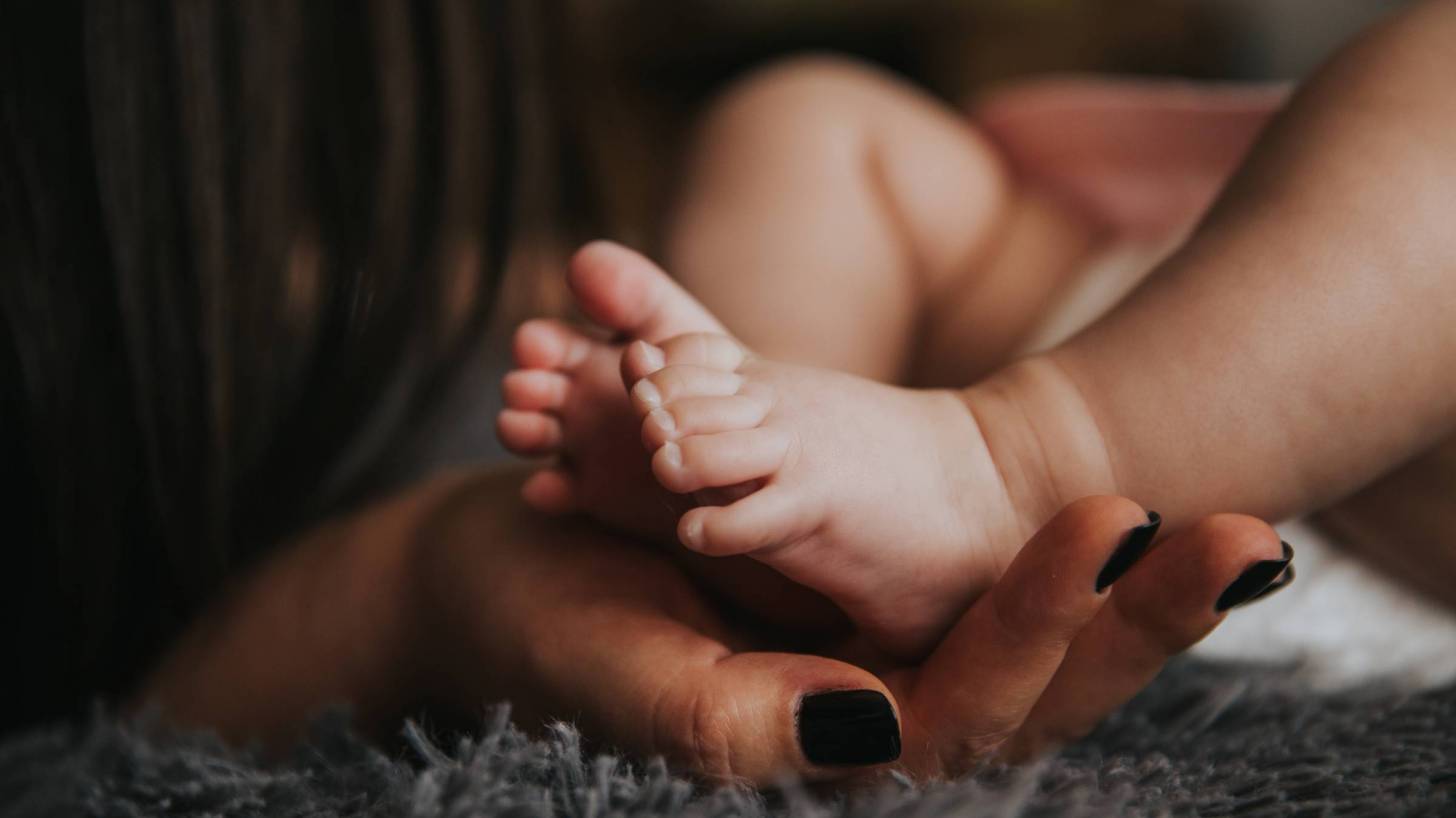 mother hand holding baby feet