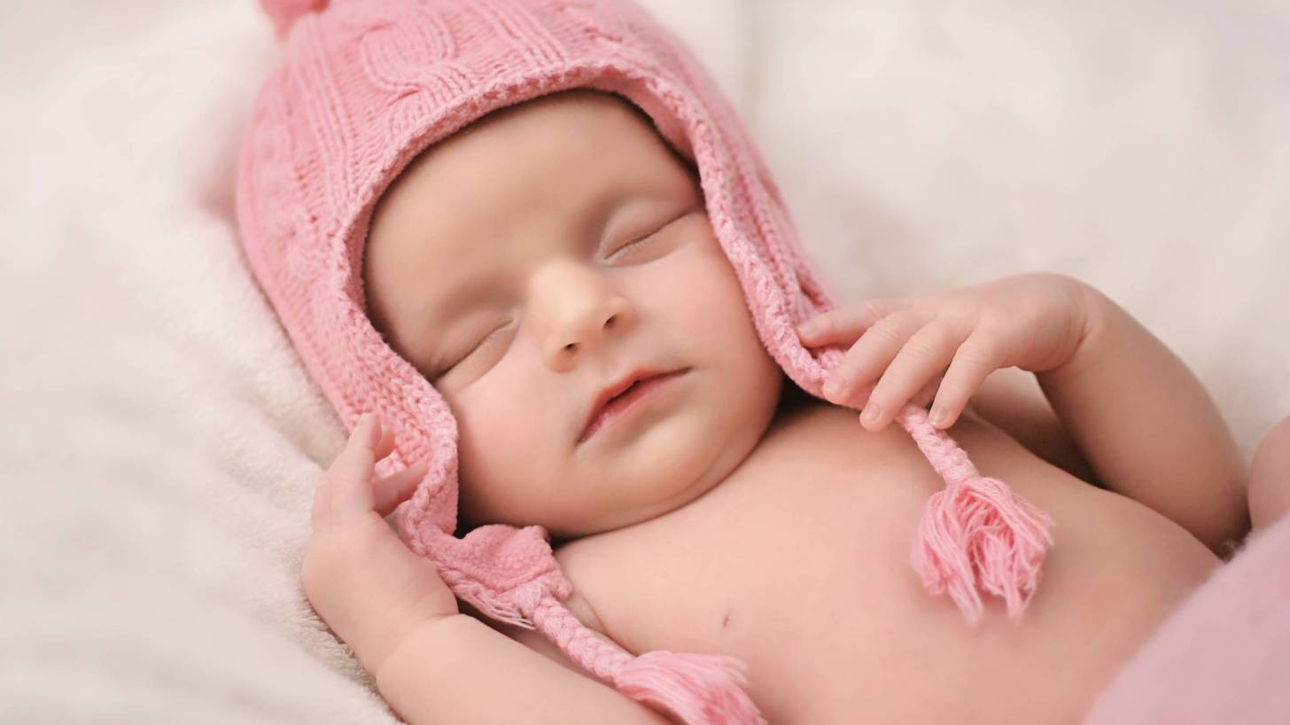 new born baby girl in a pink hat