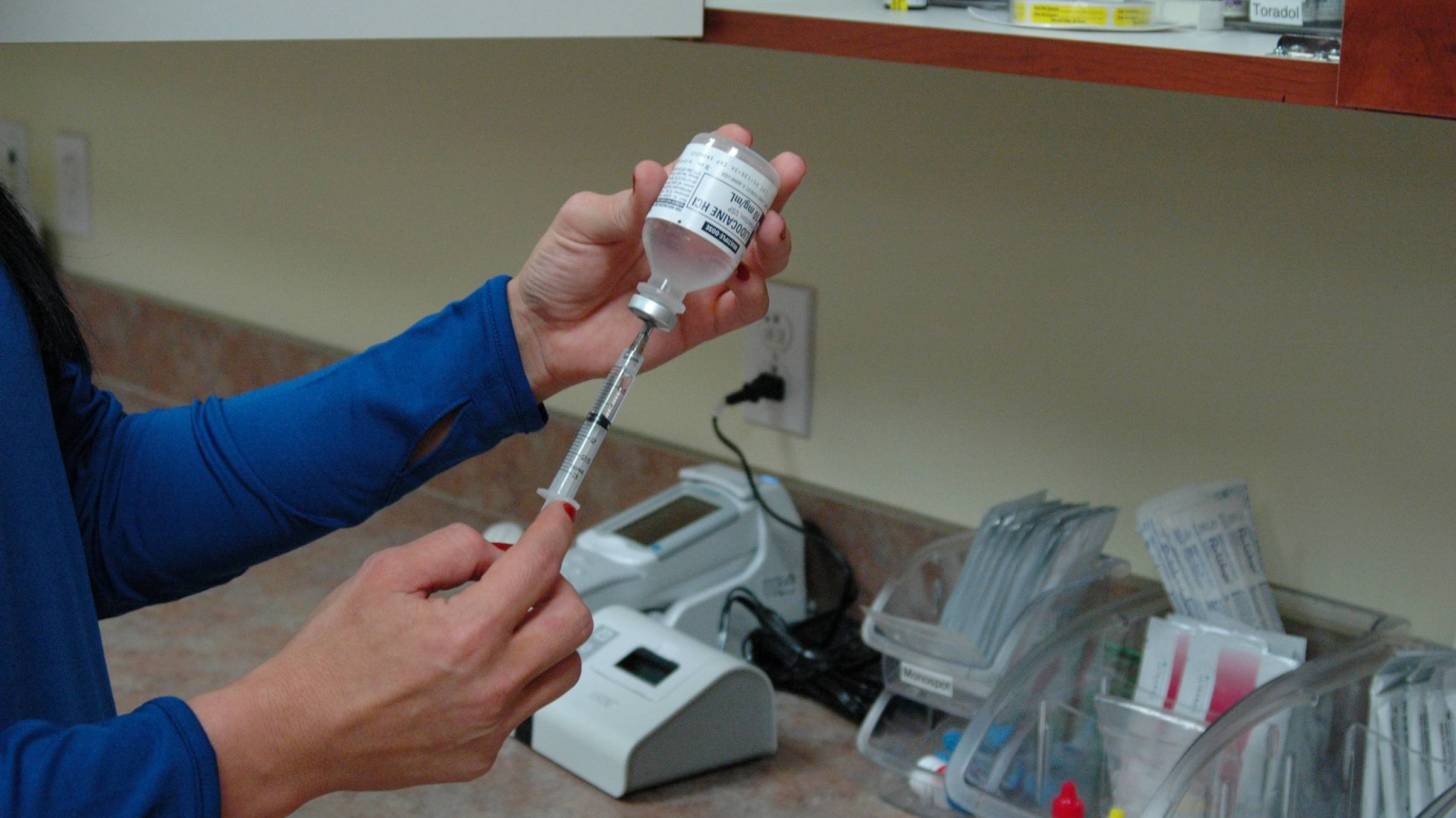 nurse filling a syringe to give a vaccination