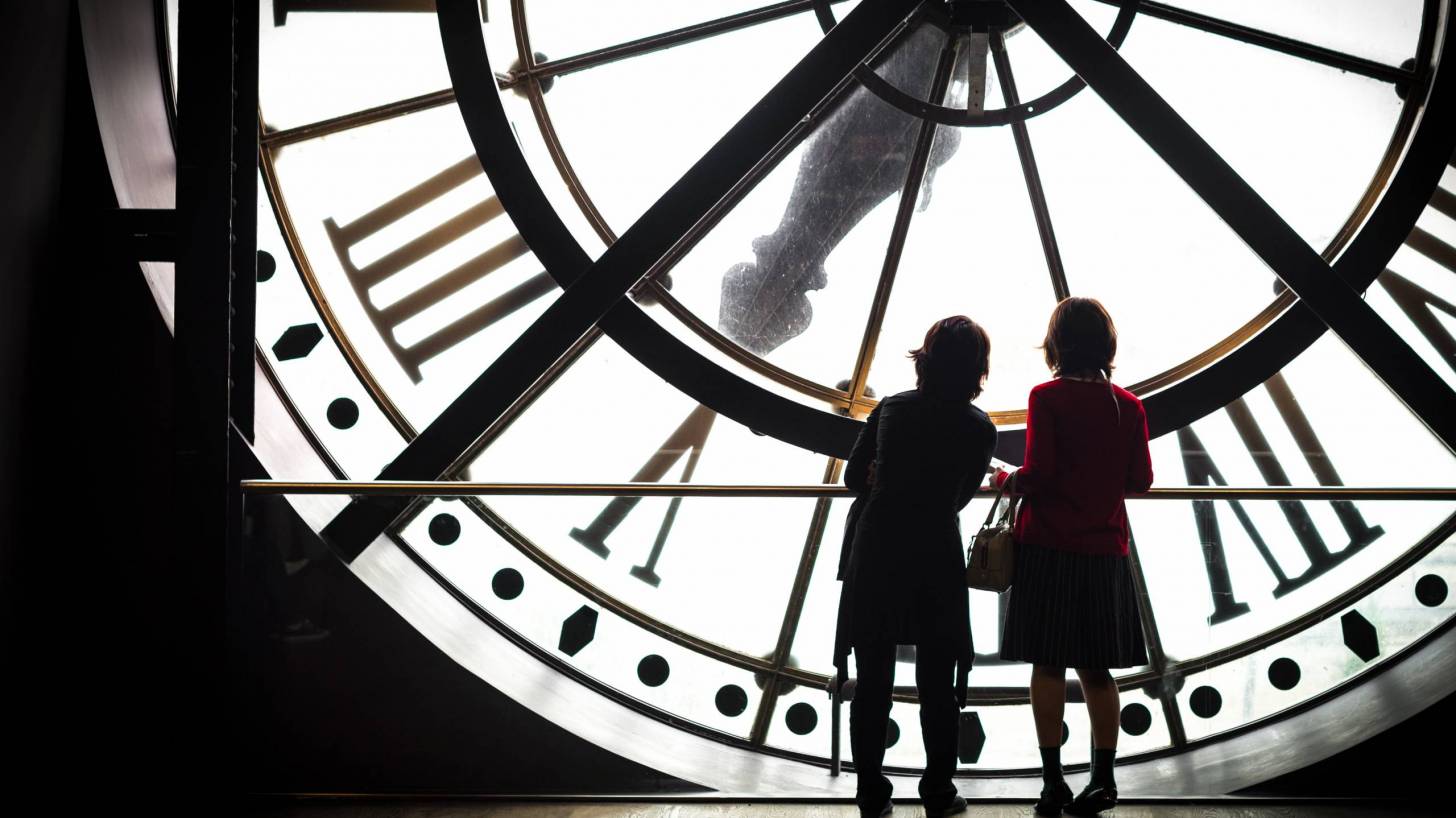 women looking at a clock
