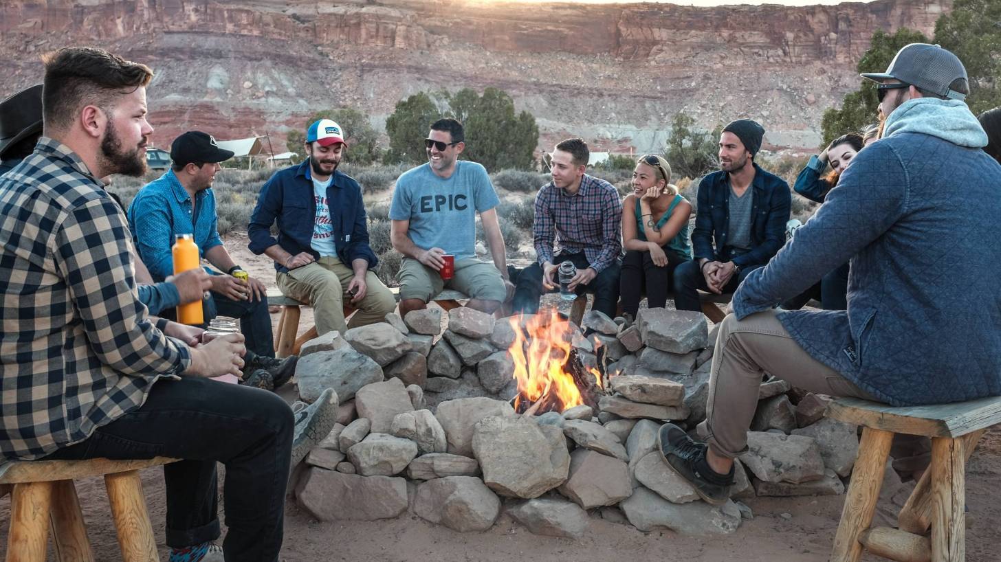 group of people sitting around a camp fire
