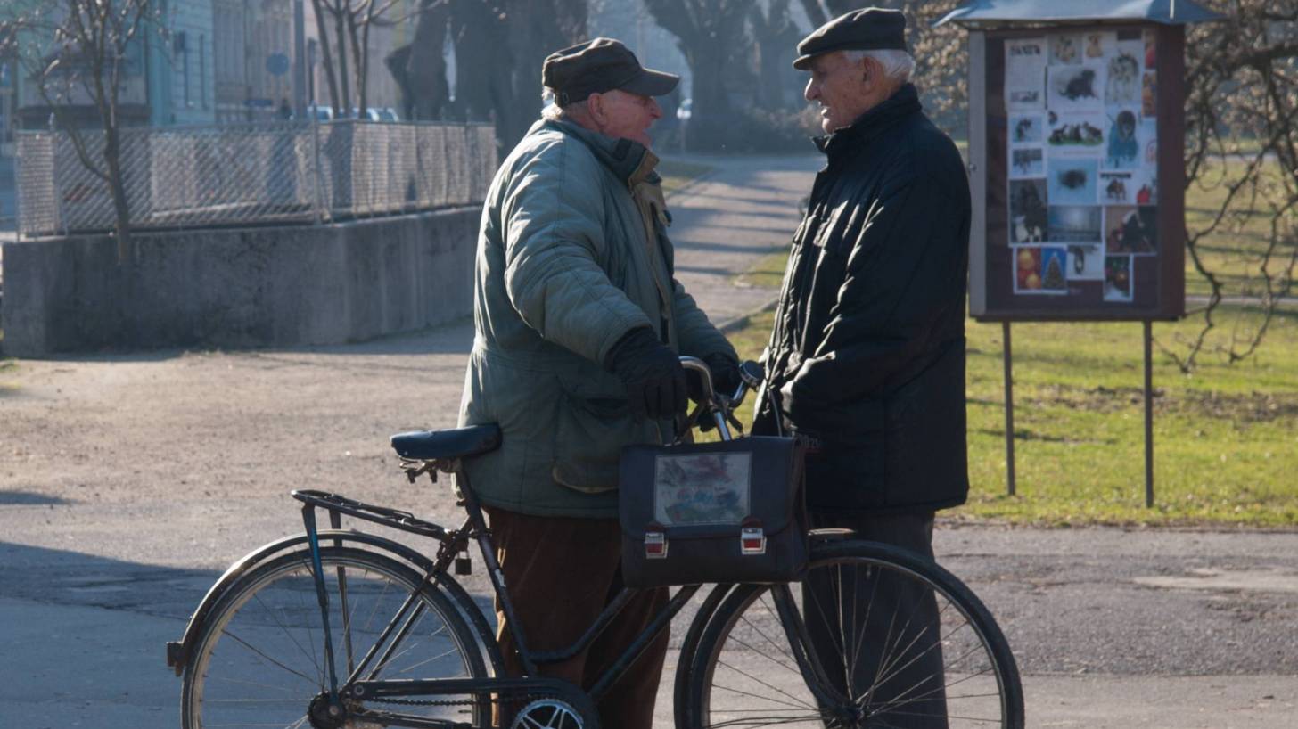 two old guys talking on a bike
