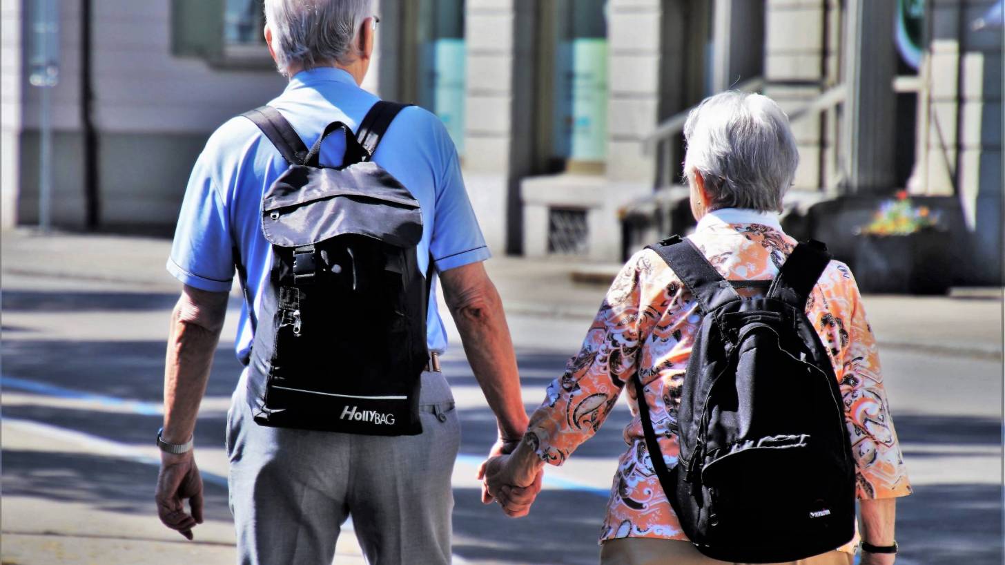 senior man and women walking holding hands