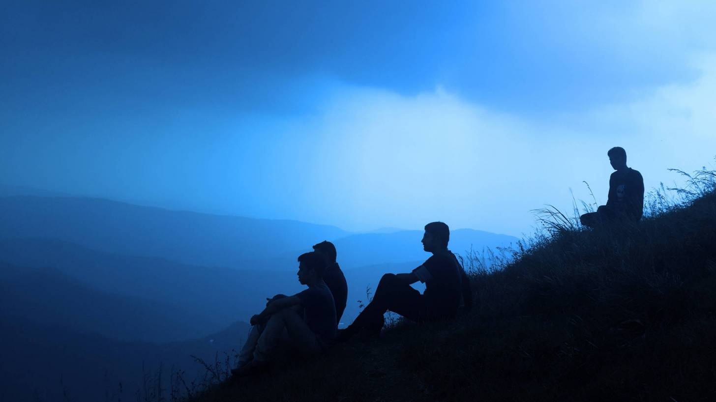 men sitting on a hill, silhouettes, looking for answers