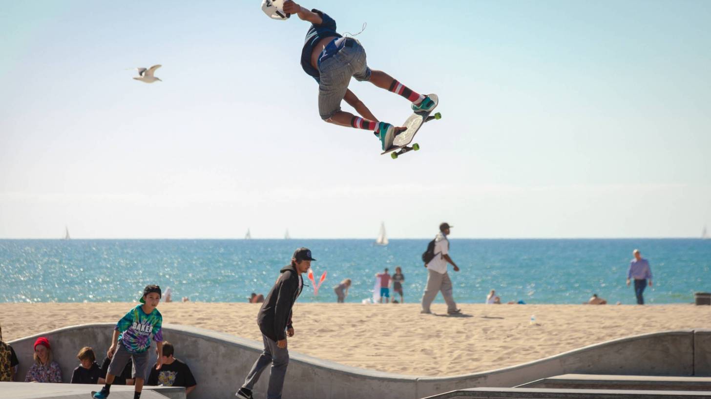 teens riding on skateboards by the beach