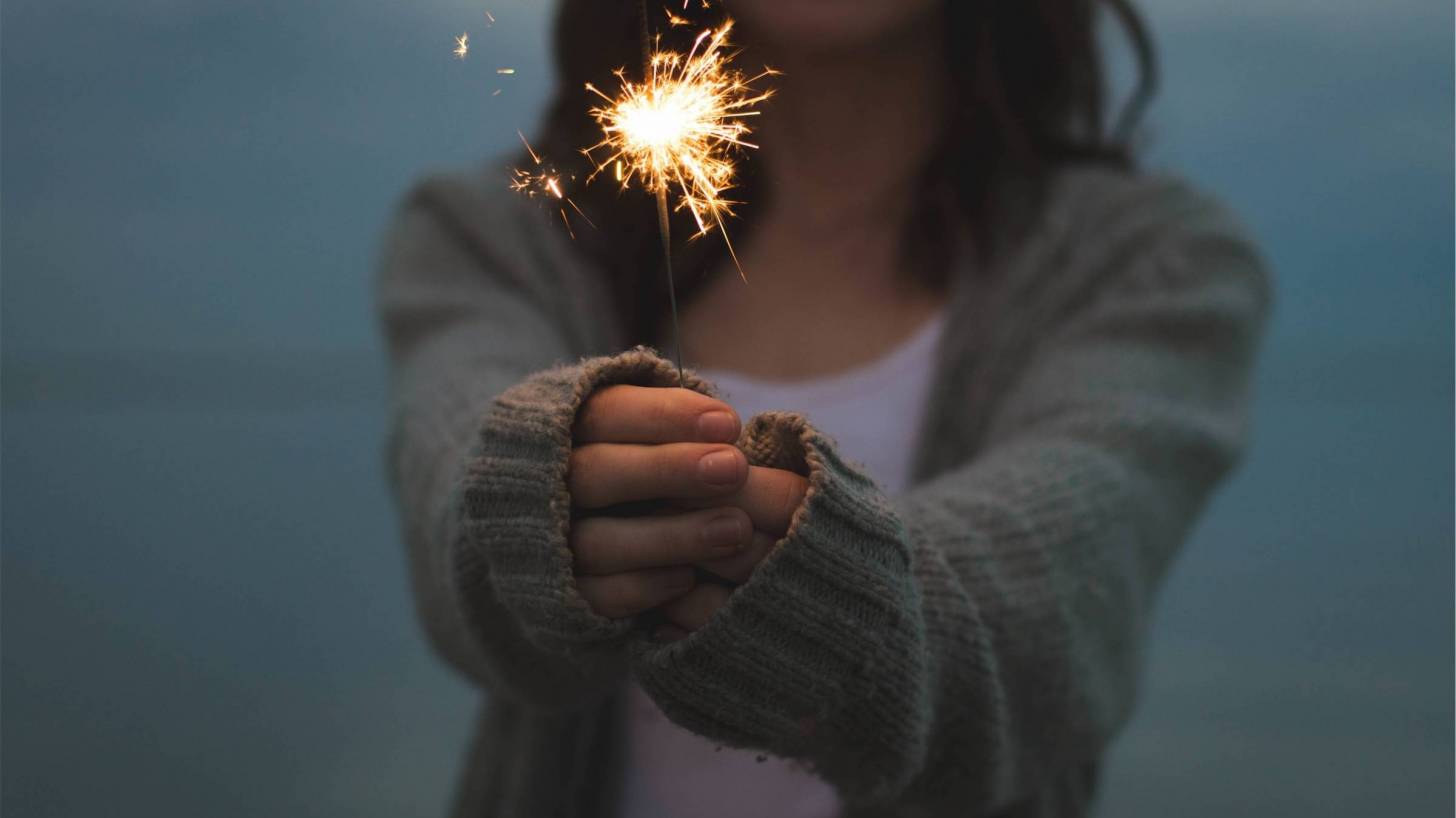 woman holding a sparkler celebrating