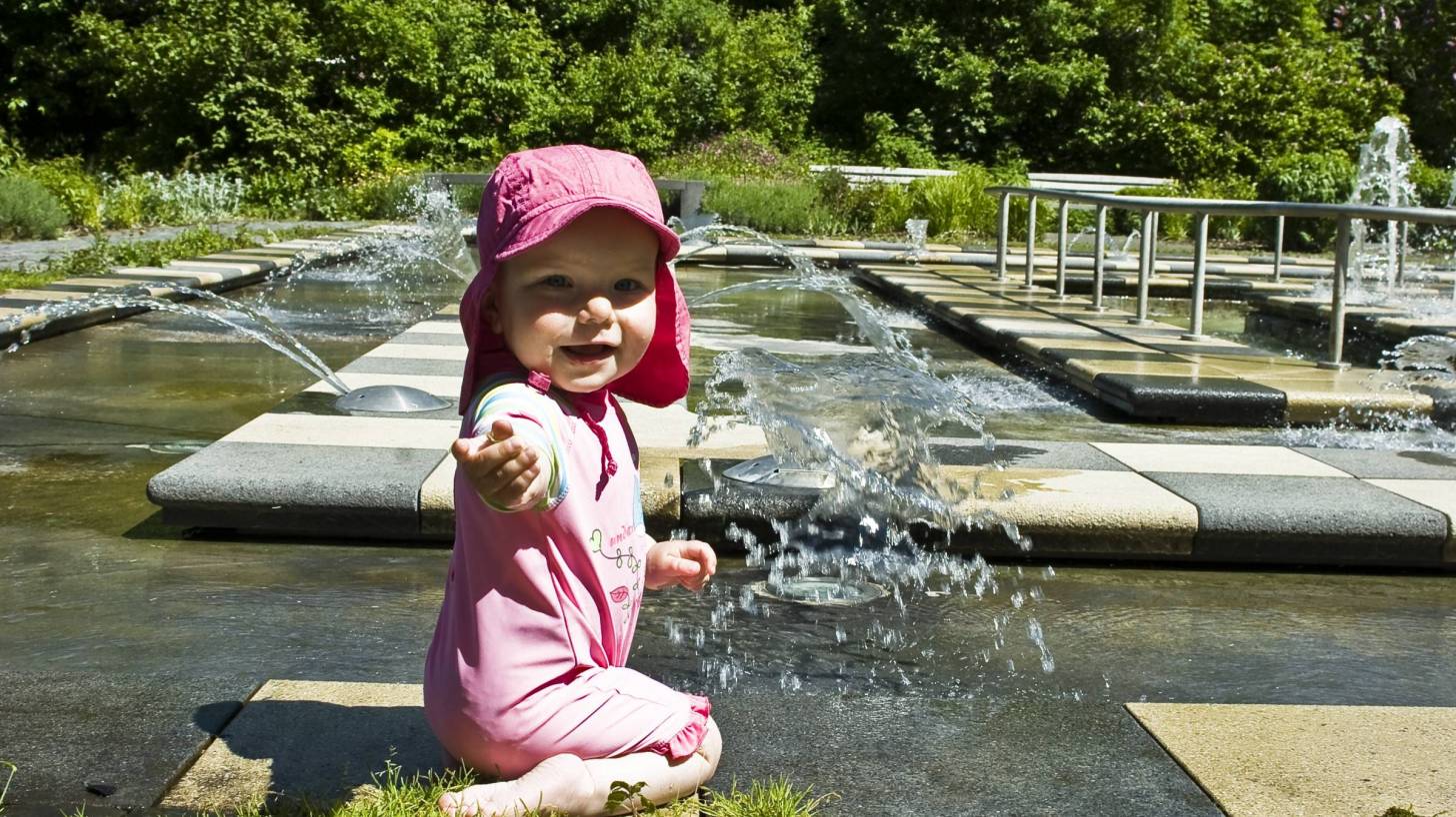 young happy girll baby playing in water