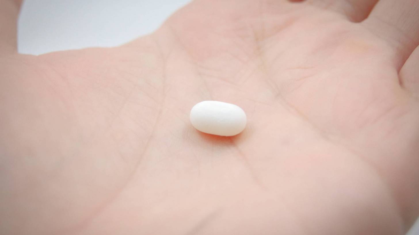 white pill in hand
