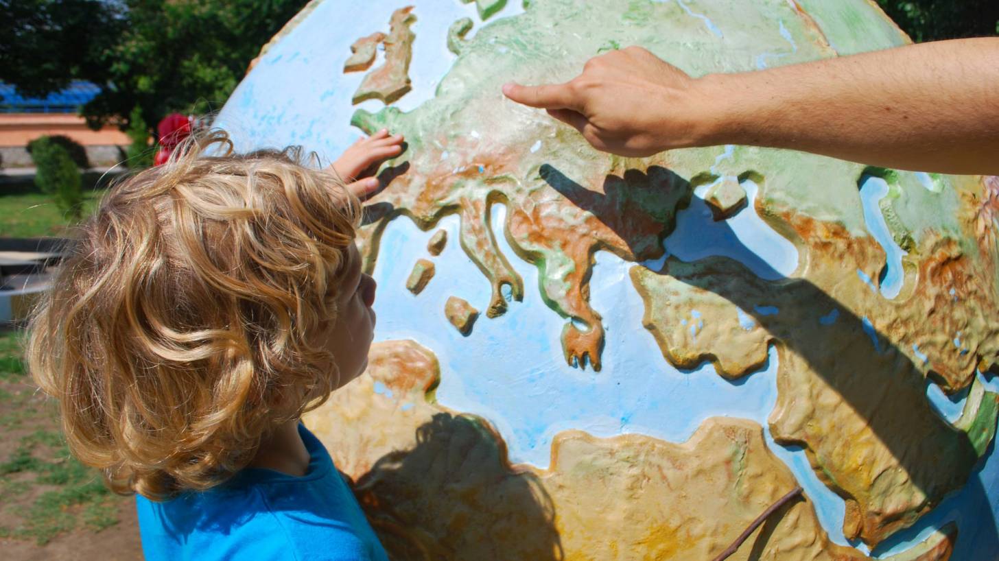 child looking at a world globe