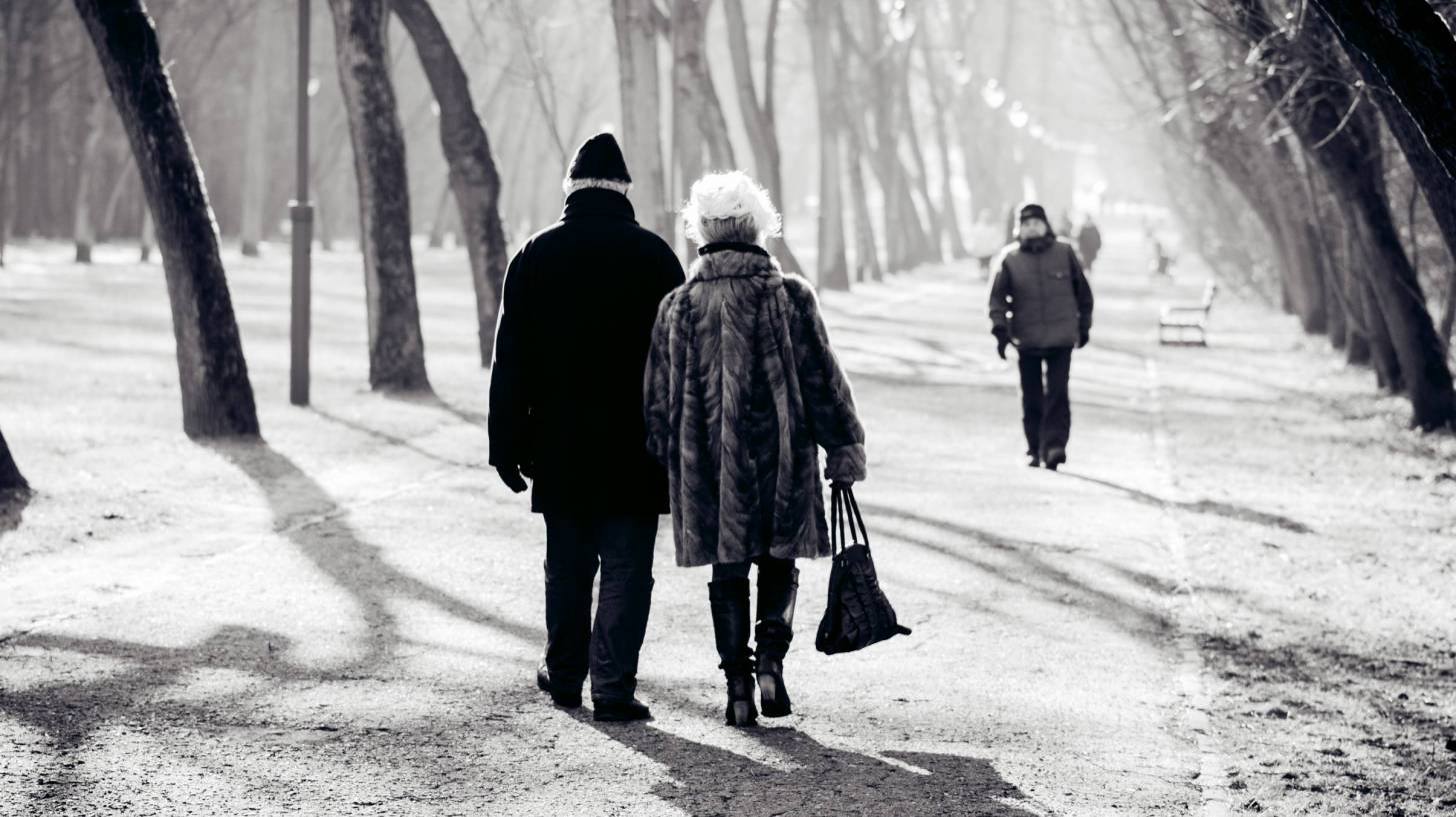 senior couple walking on a cold winter day thru a park