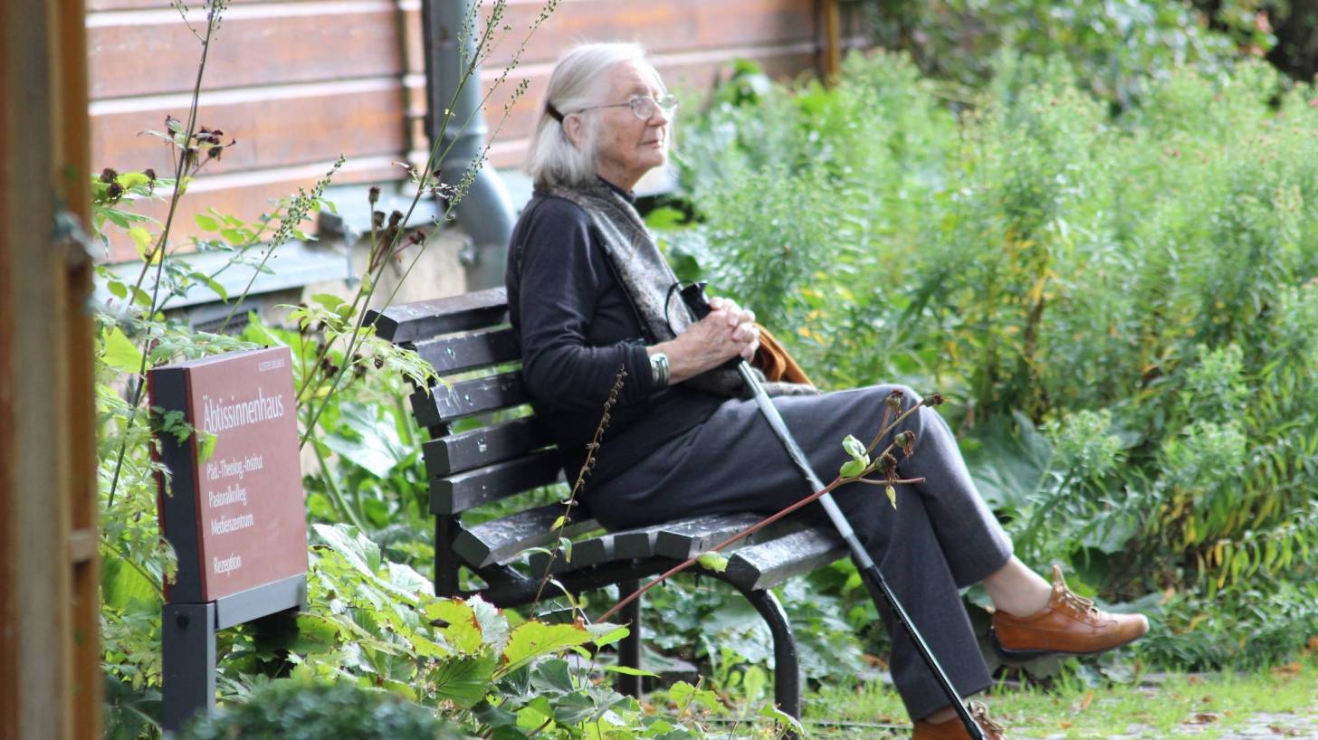 older woman sitting outside her retirement home
