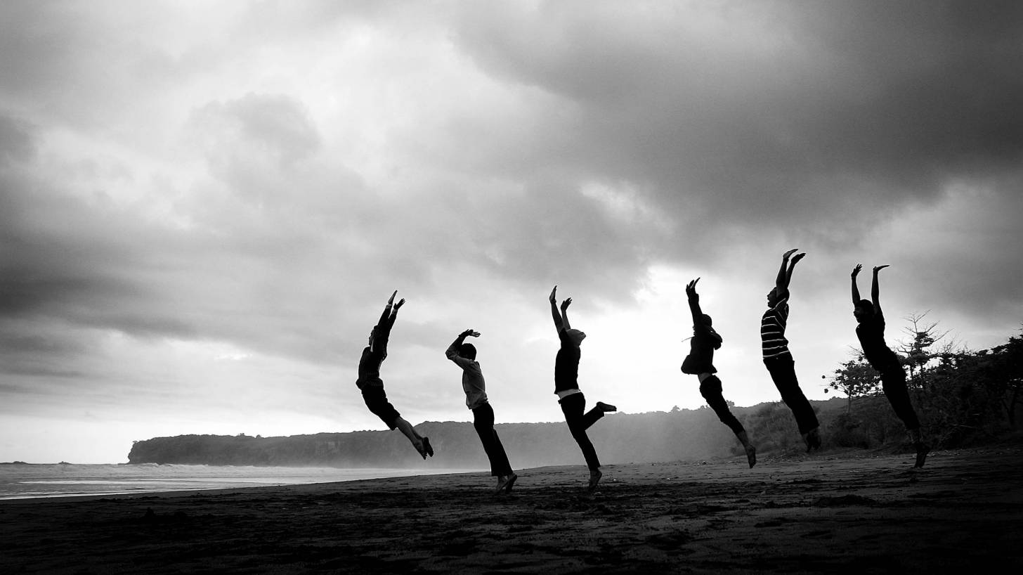 women jumping nn beach