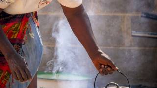 zimbabwe woman cooking over outdoor fire