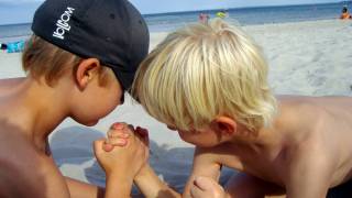 young boys arm wrestling on the beach