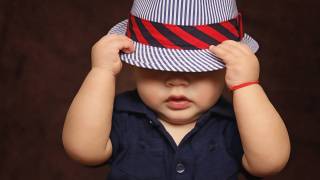 young toddler boy with hat over his eyes