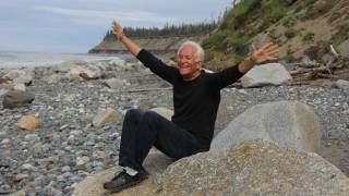 baby boomer on rocks near ocean