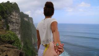couple on the cliff overlooking the ocean, holding hands