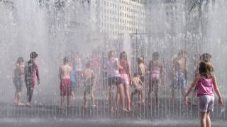 children playing in a water fountain 