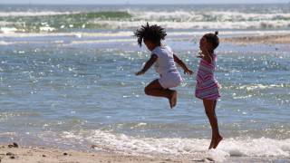 children jumping high in the ocean